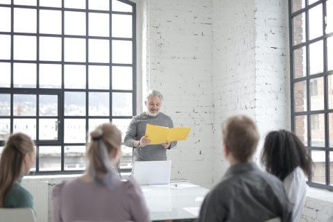 Man with a folder standing in front of a small group