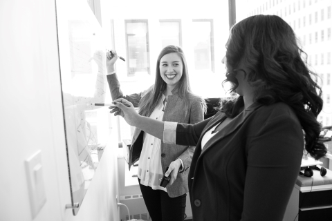 Coworkers writing on a whiteboard